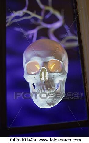 Stock Image - spooky, floating, eyes, window, glowing, Halloween, skull. Fotosearch