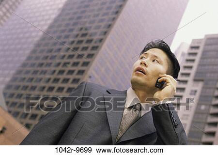 Stock Photo - talking, Asian, phone, city, business, outdoors. Fotosearch