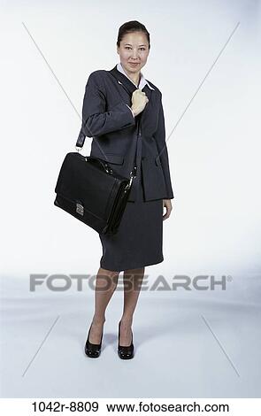 Stock Photo - woman, briefcase, Hispanic, business, indoors, travel, businesswoman. Fotosearch