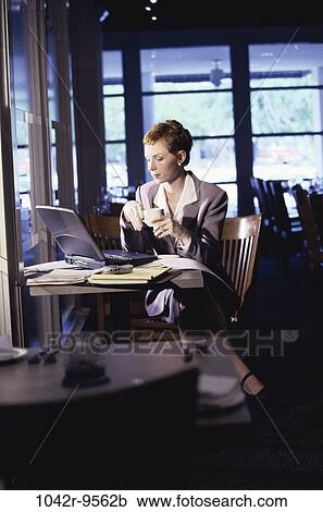 Stock Image - woman, computer, laptop, drinking, business, restaurant, using. Fotosearch