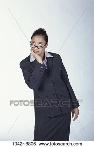 Stock Photograph - woman, eyeglasses, Hispanic, business, contemplating, indoors, contemplate. Fotosearch