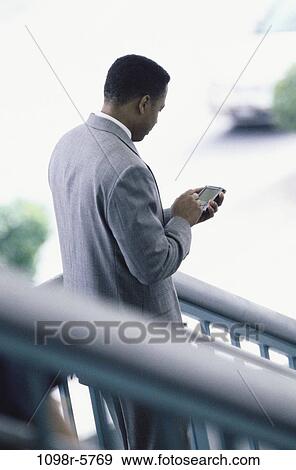Stock Photo - computer, business, outdoors, using, businessman, African-American. Fotosearch