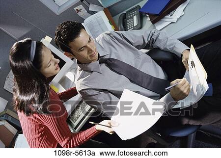 Stock Image - desk, coworkers, talking, paperwork, conversation, papers, business. Fotosearch
