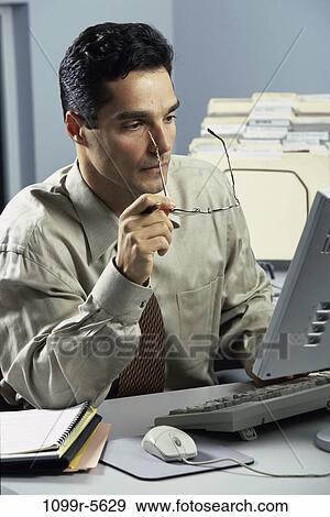 desk, eyeglasses, computer, concentrating, business, Middle-aged View Large Photo Image Stock Photo - desk, eyeglasses, computer, concentrating, business, Middle-aged. Fotosearch