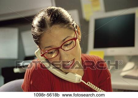Stock Image - desk, woman, talking, eyeglasses, computer, business, casual. Fotosearch