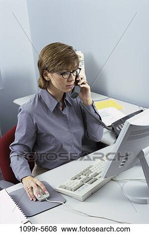 Stock Photo - desk, woman, telephone, talking, computer, phone, business. Fotosearch