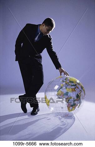 Stock Photograph - globe, business, Middle-aged, global, businessman, indoors. Fotosearch