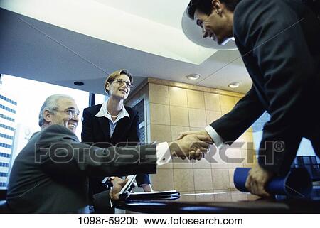 Stock Image - meeting, group, men, desk, woman, table, equipment. Fotosearch