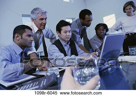 Stock Photography - meeting, multiethnic, laptop, business, Middle-aged, indoors, casual dress. Fotosearch