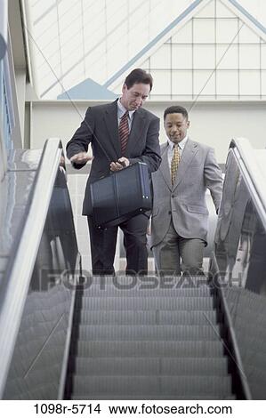 Picture - multiethnic, men, escalator, briefcase, business, Middle-aged, executives. Fotosearch