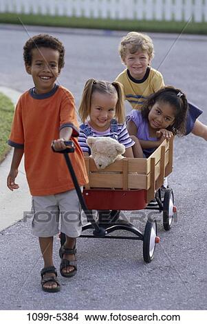 Picture - multiethnic, people, playing, riding, outdoors, pulling, friends. Fotosearch