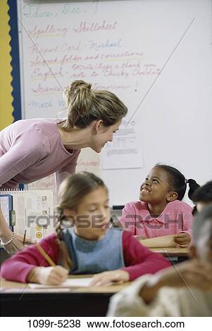 Stock Photo - multiethnic, people, talking, teacher, books, school, classroom. Fotosearch