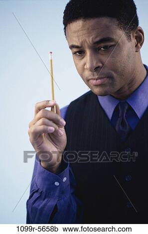 Stock Image - pencil, business, Middle-aged, contemplating, businessman, indoors. Fotosearch