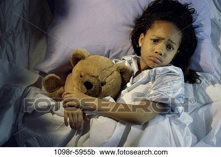 Stock Image - people, bed, girl, child, laying, sad, teddy bear. Fotosearch
