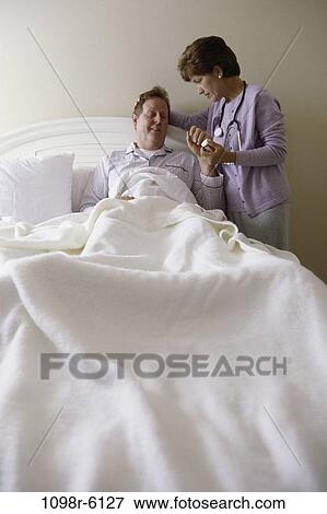 Stock Photo - people, bed, patient, nurse, stethoscope, medicine, nurturing. Fotosearch