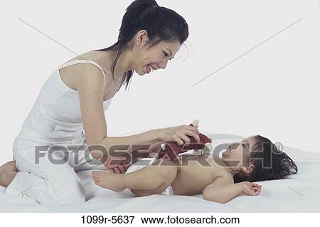 people, Brown, Asian, mother, bed, playful, family View Large Photo Image Stock Photo - people, Brown, Asian, mother, bed, playful, family. Fotosearch