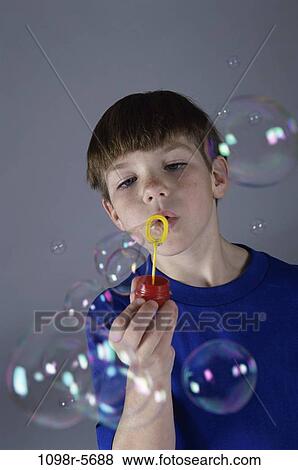 Stock Photo - people, bubbles, boy, blowing, child, brunette, indoors. Fotosearch