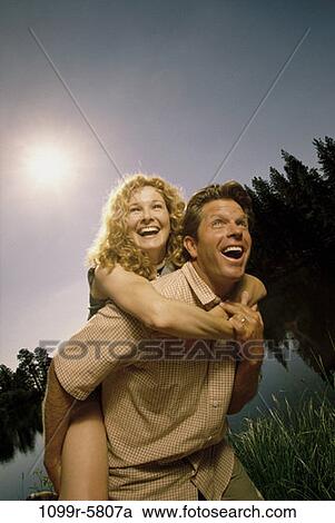 Stock Image - people, couple, outdoors, carrying, piggyback, Caucasian, carry. Fotosearch