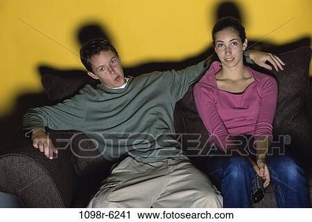Stock Image - people, couple, watch, couch, watching, television, teens. Fotosearch