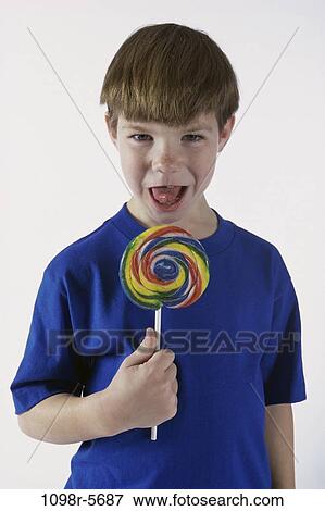 Stock Photo - people, eating, licking, candy, boy, child, brunette. Fotosearch