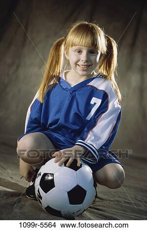 Picture - people, girl, child, uniform, indoors, soccer, soccer ball. Fotosearch