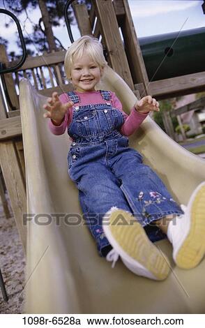 Stock Image - people, girl, sliding, playground, outdoors, child, blond. Fotosearch
