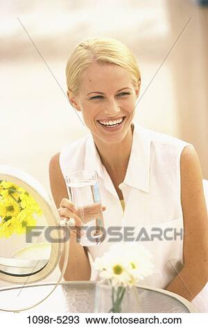 Stock Image - people, glass, water, woman, smiling, drinking, laughing. Fotosearch