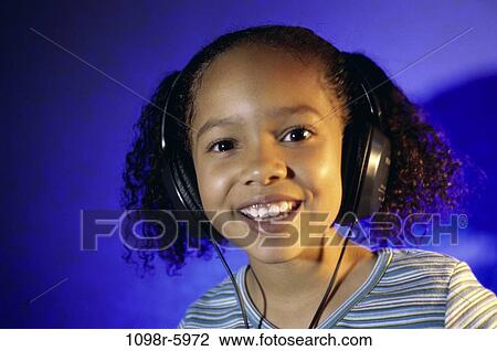 Stock Image - people, headset, listening, music, girl, child, indoors. Fotosearch