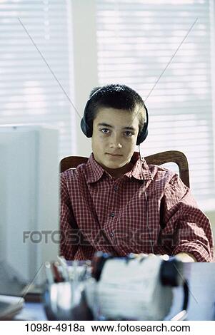 Stock Image - people, headset, male, listening, Hispanic, computer, using. Fotosearch