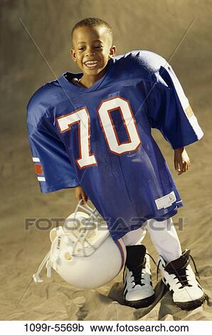 Stock Image - people, helmet, football, boy, uniform, indoors, player. Fotosearch