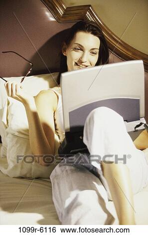 people, home, woman, eyeglasses, computer, laptop, bed View Large Photo Image Stock Photograph - people, home, woman, eyeglasses, computer, laptop, bed. Fotosearch