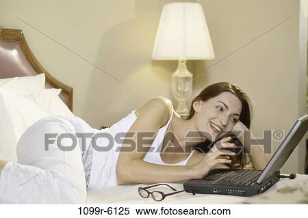 people, home, woman, eyeglasses, computer, laptop, bed View Large Photo Image Stock Photography - people, home, woman, eyeglasses, computer, laptop, bed. Fotosearch