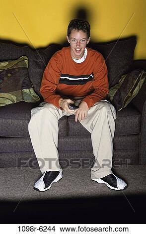 Picture - people, male, watch, couch, watching, television, brunette. Fotosearch