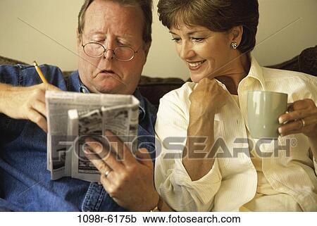 Stock Image - people, newspaper, couple, eyeglasses, coffee, puzzle, drinking. Fotosearch