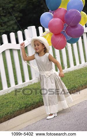 Stock Image - people, party, formal, hat, walking, balloons, girl. Fotosearch