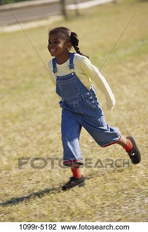 Stock Image - people, running, girl, outdoors, child, overalls, African-American. Fotosearch