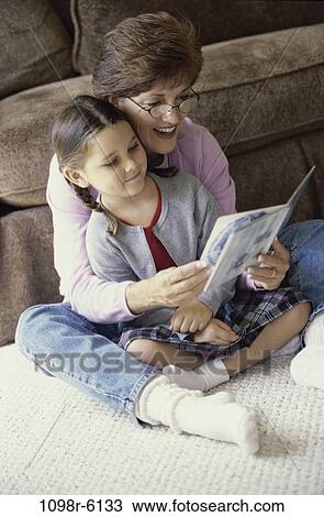 Stock Image - people, sitting, reading, floor, book, family, brunette. Fotosearch