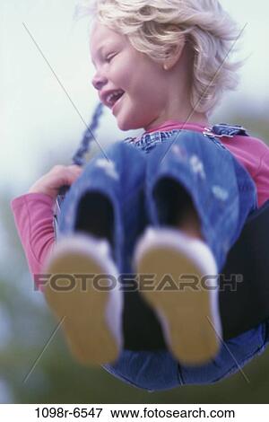 Stock Photo - people, swinging, girl, swing, outdoors, child, blond. Fotosearch
