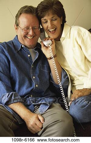Stock Photograph - people, telephone, talking, couple, eyeglasses, phone, laughing. Fotosearch