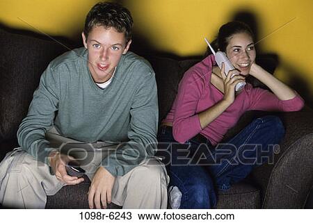 Stock Image - people, telephone, talking, phone, watch, couch, watching. Fotosearch