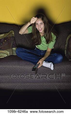 Stock Image - people, watch, couch, watching, television, brunette. Fotosearch
