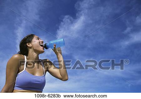 Stock Image - people, water, woman, Hispanic, drinking, health, outdoors. Fotosearch