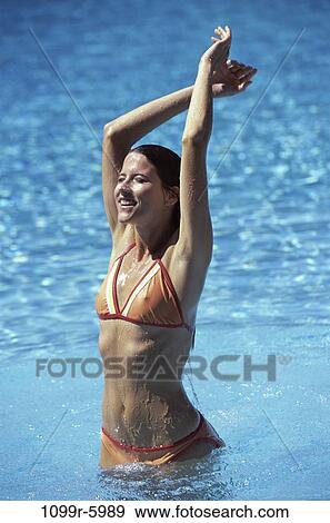 Stock Photo - people, woman, beach, brunette, swimwear, young adult, Young women pool. Fotosearch