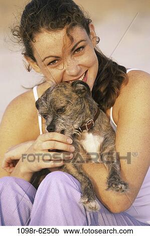Stock Image - people, woman, dog, puppy, pet, holding, outdoors. Fotosearch