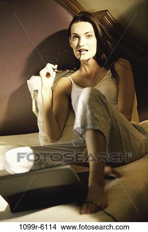 Picture - people, woman, eyeglasses, laptop, bed, contemplating, brunette. Fotosearch