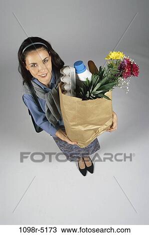 Stock Image - people, woman, Hispanic, carrying, shopping, grocery, food. Fotosearch