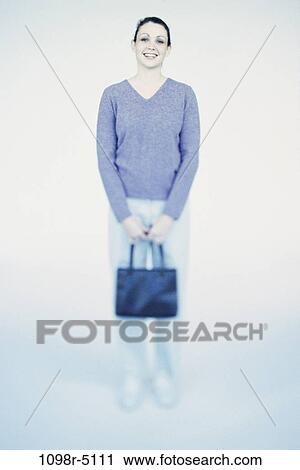 Stock Image - people, woman, purse, brunette, indoors, Caucasian, young adult. Fotosearch