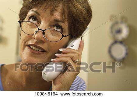 people, woman, telephone, talking, eyeglasses, phone, Middle-aged View Large Photo Image Picture - people, woman, telephone, talking, eyeglasses, phone, Middle-aged. Fotosearch