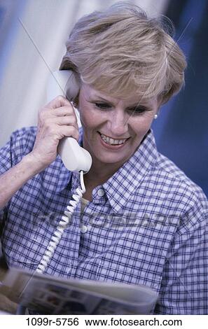 Stock Photograph - people, woman, telephone, talking, senior, magazine, reading. Fotosearch
