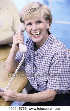 Stock Photograph - people, woman, telephone, talking, senior, phone, indoors. Fotosearch